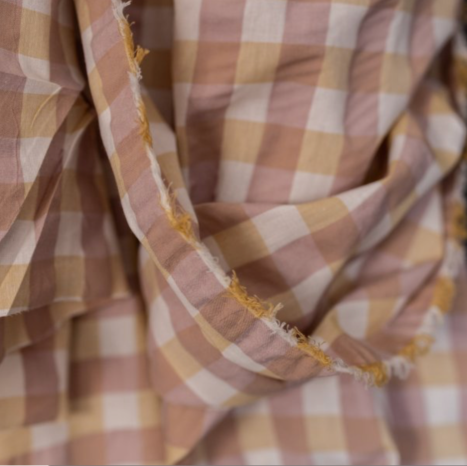 Close-up of a checkered fabric with light brown, beige and ecru colors.