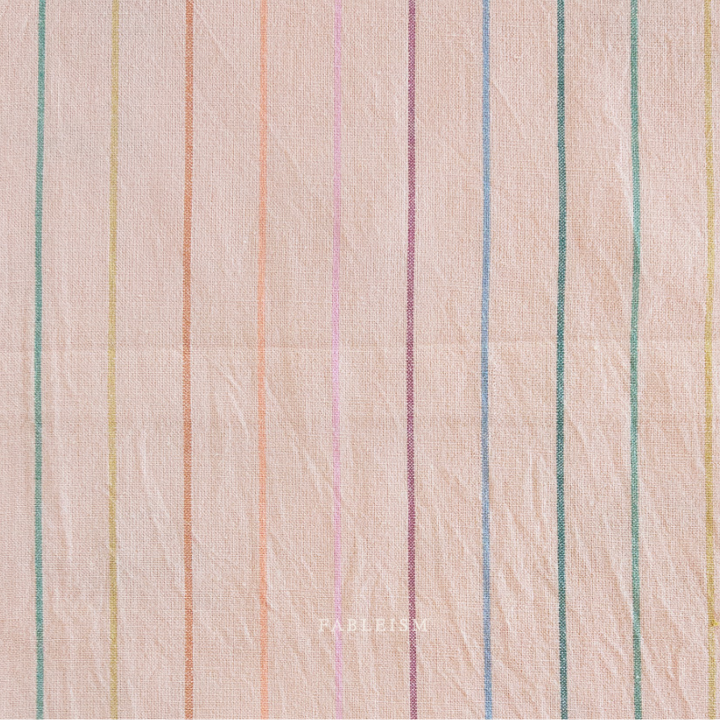 A close-up of a fabric surface with pink base and thin vertical multicolor stripes in muted pastel tones including green, blue, pink, and yellow. 