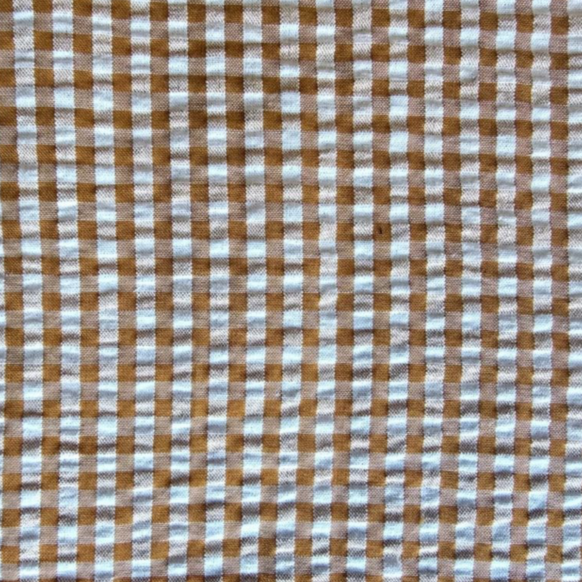 A close-up of a brown and white gingham checkered fabric pattern.
